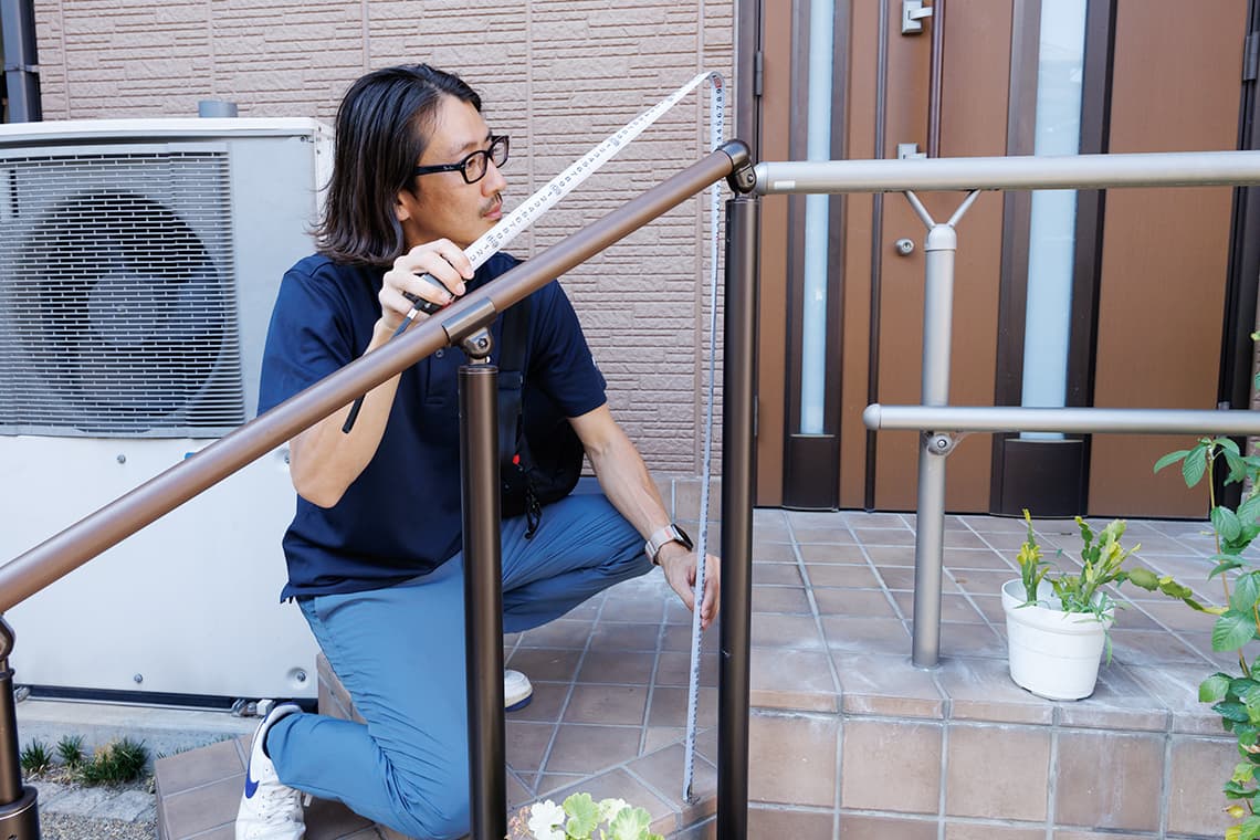 玄関階段の手すりの高さを測っている様子